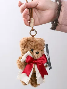 Cute brown teddy bear plush keychain with red bow tie and hanging strap for bags.