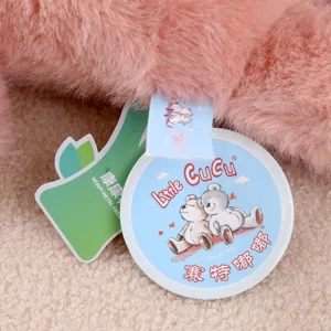Vista dettagliata dell'etichetta del peluche con pelliccia sintetica rosa e marchi vicini.