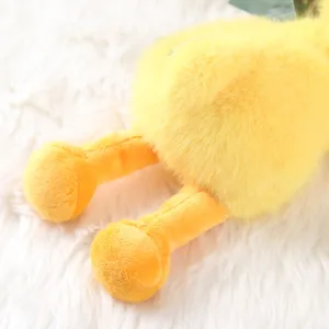 Soft fuzzy yellow plush duck toy detail shot showcasing cute orange feet and fluffy texture.
