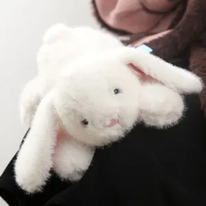 Primo piano dettagliato di un morbido coniglietto di peluche bianco con lunghe orecchie.