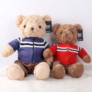 Cute plush teddy bear stuffed animal toy pair wearing knitted sweaters for gift and children play.
