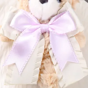 Cute brown bear plush toy bag pendant with elegant purple and beige layered ribbon bow.