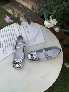 Detailed top view of silver Mary Jane shoes with double straps and double bows for women.