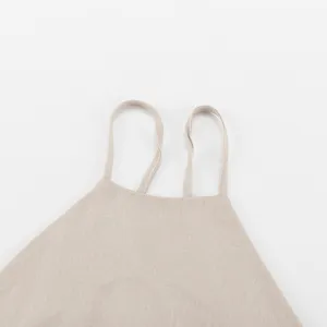 Linen blend dress detail, close-up of thin double halter straps, casual summer style.