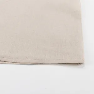 Cotton linen dress hem detail close-up view showing fine stitching and natural fabric texture.