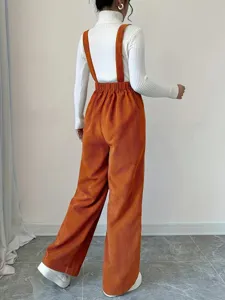 Detail shot showing the back view of casual high waist corduroy overalls in vibrant rust orange.