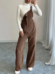 Detail view of women's brown corduroy overalls paired with a white ribbed turtleneck sweater.