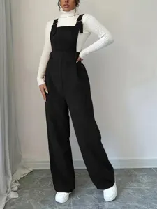 Black corduroy overalls paired with white ribbed turtleneck sweater detail view, casual style.