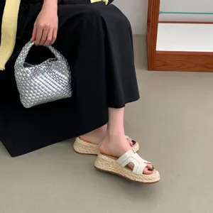 Detailaufnahme von Damen-Keilsandaletten in Beige mit gewebter Espadrille-Sohle.
