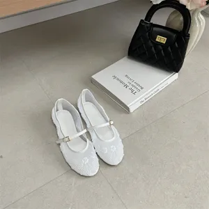 White beaded Mary Jane flat shoes detail shot, elegant mesh design with buckle strap.