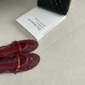 Detail shot of the new 2026 autumn flat shoes in dark red with chic beaded embroidery.