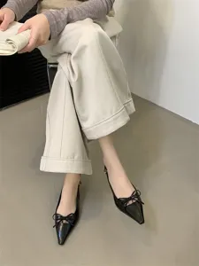 Elegantes zapatos negros de tacón con punta fina y elegante lazo decorativo para mujer.