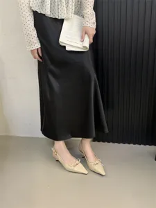 Vista detallada de elegantes zapatos slingback beiges de tacón bajo con lazo decorativo.