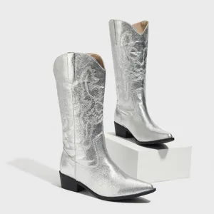 Dettaglio di stivali texani western argento metallizzato con ricami intricati e tacco largo.