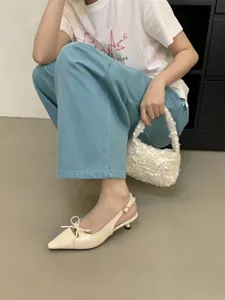 Elegantes zapatos slingback de tacón bajo beige con punta puntiaguda y lazo bonito.