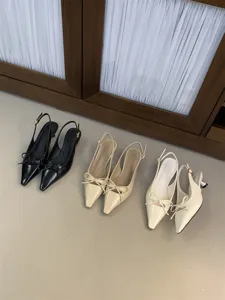Vista detallada de elegantes tacones de punta fina con lazo, excelente acabado y diseño.