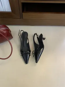 Zapatos slingback negros de tacón bajo con punta puntiaguda y lazo, elegantes.