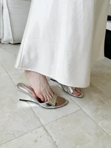Silver metallic wedge sandals detail shot showing open-toe mule design and glossy finish.