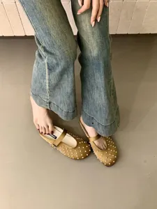 Detail shot of gold satin mule shoes with pearl embellishments, elegant footwear close-up