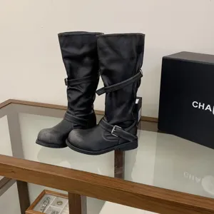 Detailed view of women distressed black motorcycle boots, chunky heel knee high biker shoes