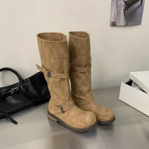 Retro distressed knee-high motorcycle boots for women with chunky heels and double buckles.