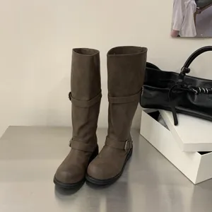 Retro distressed knee-high biker boots for women with chunky heels and stylish buckles.
