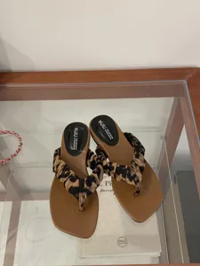 Nahaufnahme flacher Zehentrenner-Sandalen für Damen mit modischem Leopardenmuster-Riemen.