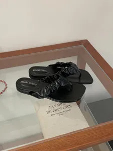 Schwarze flache Zehentrenner für Damen im Sommer Strand bequeme geraffte Riemen Detail.