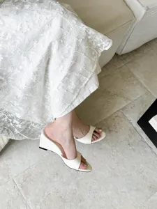 Detail view of white open-toe wedge high heel sandals showcased in elegant daily scene.