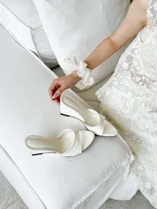 Elegant white open-toe wedge sandals featuring a stylish slip-on mule design for chic summer wear.