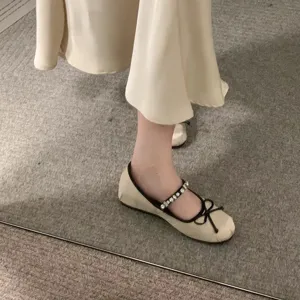 Vista dettagliata di ballerine Mary Jane da donna con strass, cinturino e fiocco elegante.