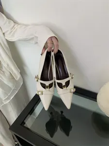 Elegant white pointed toe kitten heels with double straps and chic gold hardware for women.