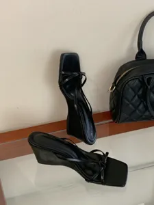 Sandales noires à talons compensés, bout carré et brides fines pour femmes élégantes.