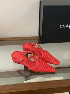 Mules slingback rojas trenzadas con punta afilada, cuña baja y elegante botón de camelia.