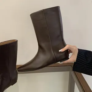 Dark brown leather mid-calf boots detail shot, showcasing square toe and minimalist pull-on design.