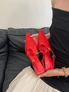 Detalle de mules rojos con puntera tejida, zapatos slingbacks elegantes en primer plano.