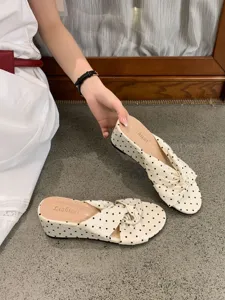 Vue détaillée des sandales compensées élégantes à pois avec des brides croisées pour l'été.