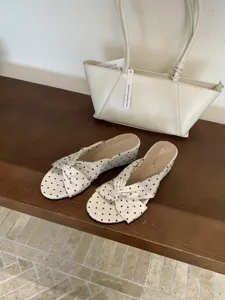 Vue détaillée de sandales compensées chic à motif pois et élégante bride nouée.
