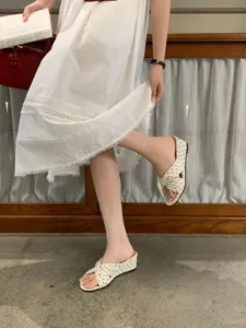 Vue détaillée de sandales compensées à pois de style français, bout ouvert et brides croisées.