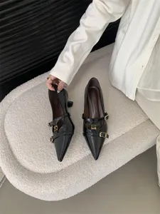 Detail view of black pointed toe kitten heel dress shoes with double straps and buckle.