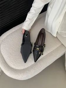 Black patent leather pointed toe kitten heels with double metal buckle strap details.