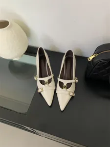 Elegant cream pointed toe kitten heels with multiple buckle straps and stylish metal hardware.