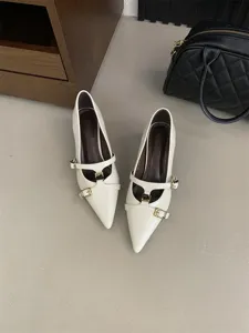 Detailed view of white pointed kitten heels with stylish multi-buckle straps and chic retro design.