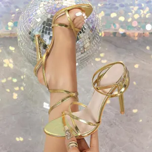 Metallic champagne strappy stiletto high heels, elegant crossover sandals for parties.