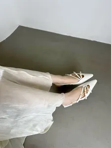 Elegant patent leather pointed toe slingback kitten heels with multi-strap buckle details.