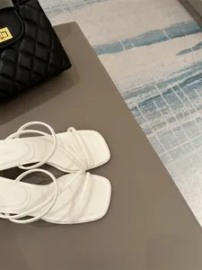Λεπτομερης οψη γυναικειων λευκων πεδιλων με τετραγωνη μυτη και λεπτα λουρακια, κομψα σχεδια.