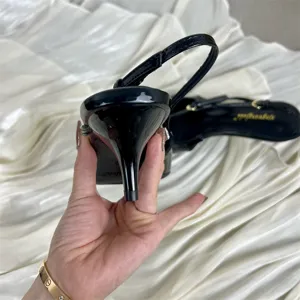 Black patent leather slingback kitten heels with pointed toe and elegant strap design for women.