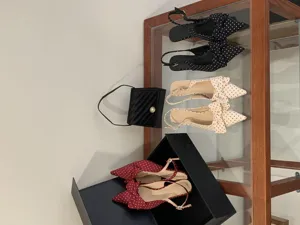 Detailed shot of stylish polka dot pointed-toe slingback women shoes displayed on a glass shelf.