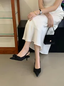 Elegant pointed-toe slingback kitten heels with charming polka dots and bow detail.