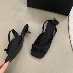 Detailansicht französischer eleganter Stilettos mit Schleife und feinem Knöchelriemen.